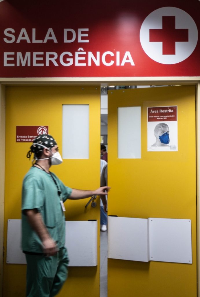 Médico abre a porta da sala de emergência em um hospital